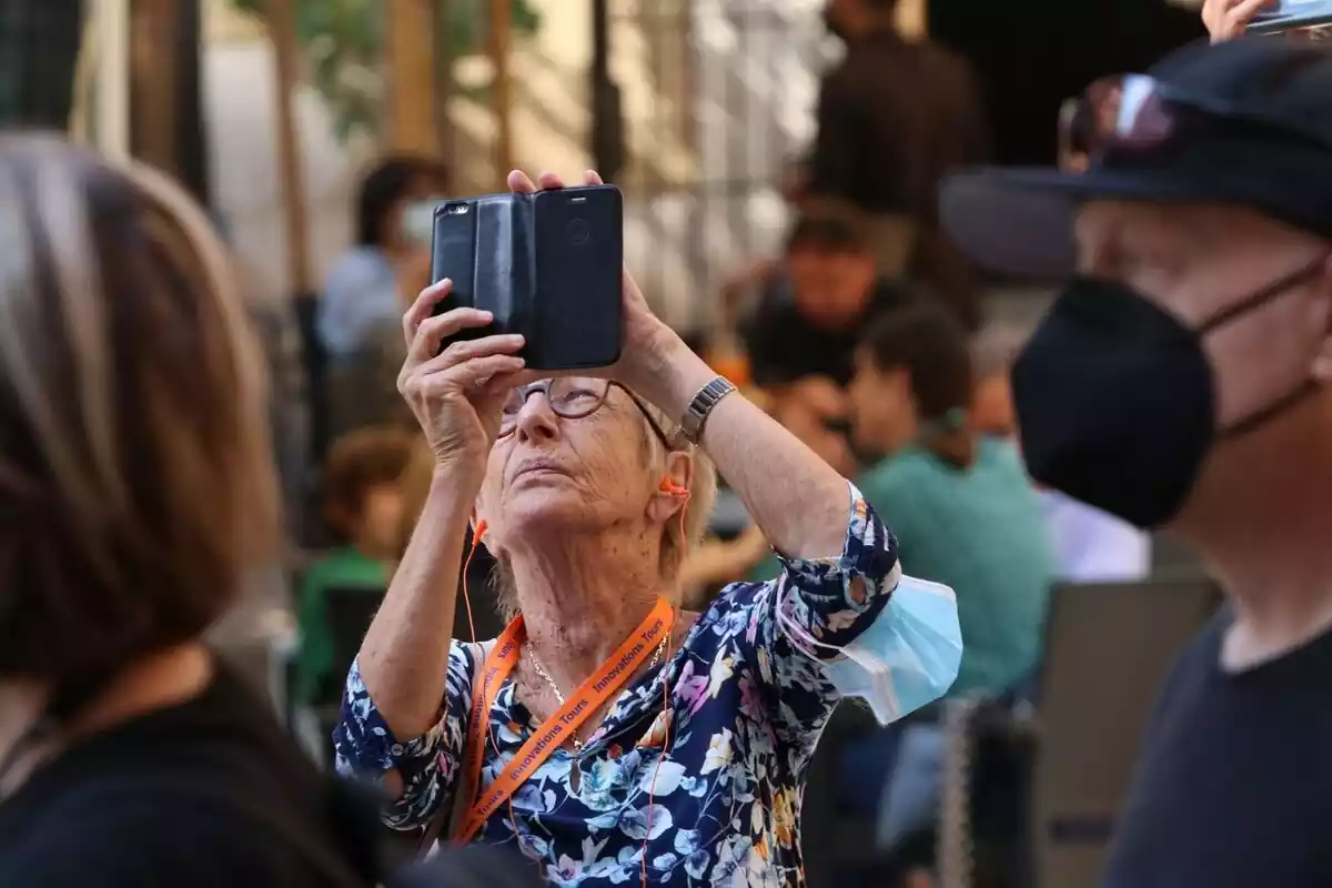 Una mujer jubilada haciendo fotos con su teléfono móvil