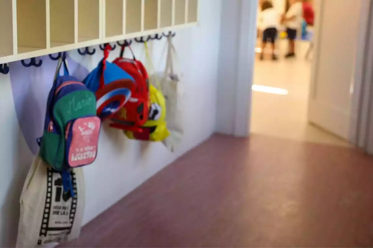 Varias mochilas de colores colgadas en una clase en un colegio de Madrid