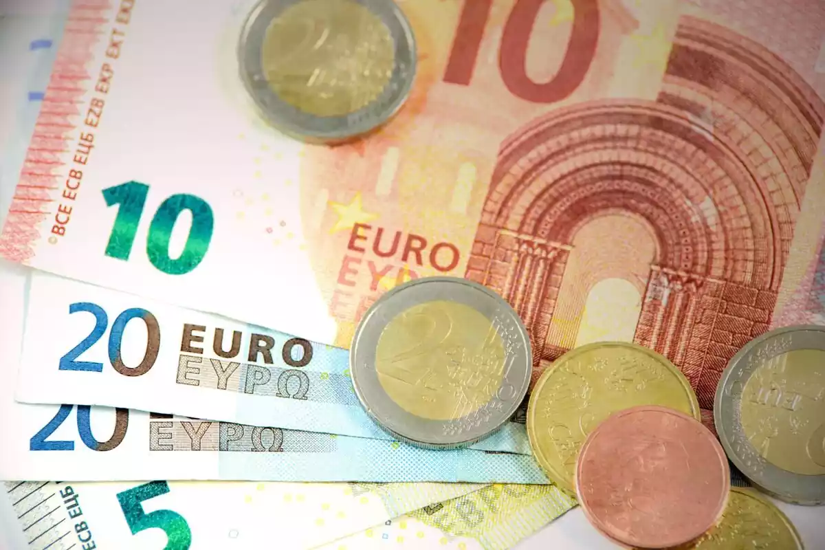 Billetes de 10, 20 y 5 euros junto a monedas de 2 euros y varios céntimos