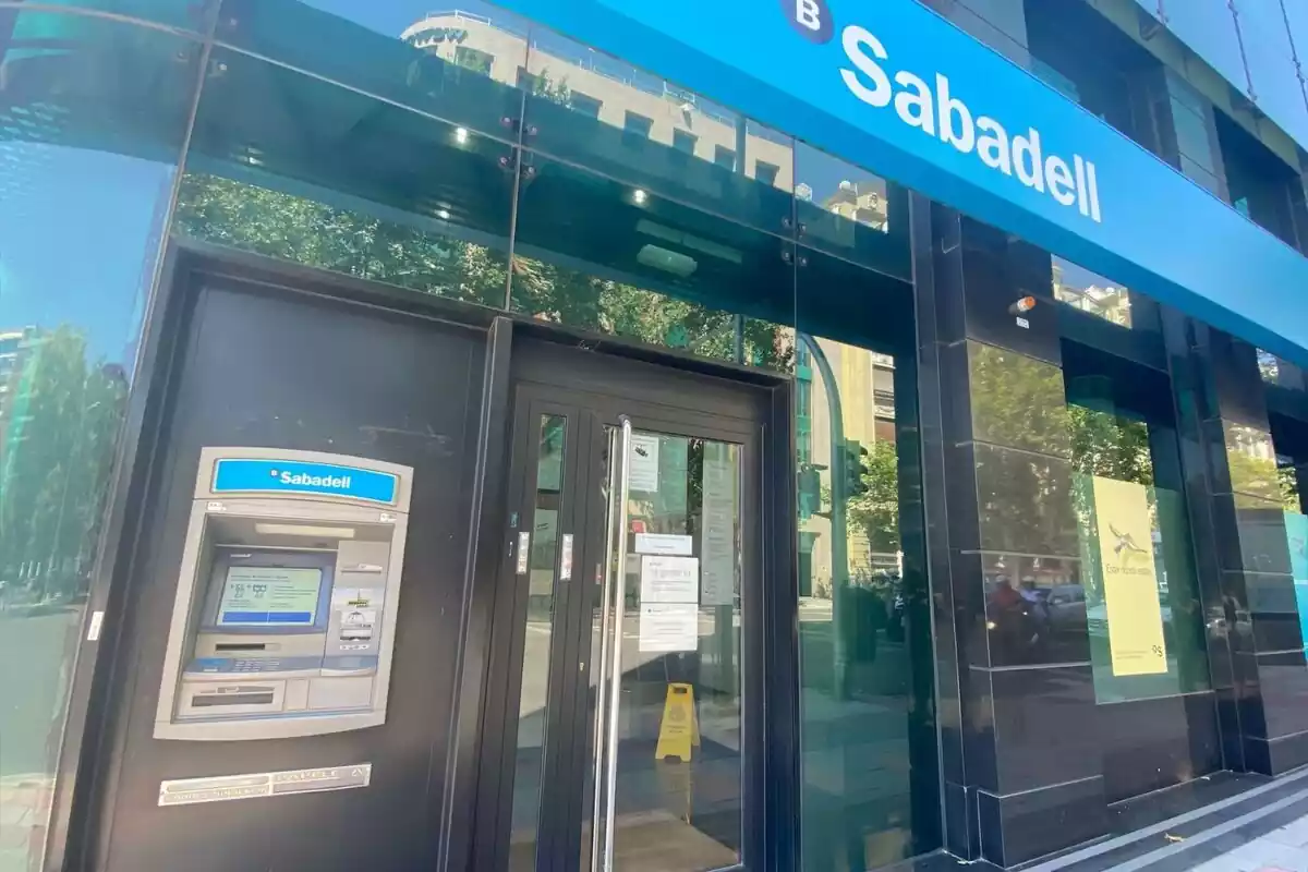 Una oficina del Banco Sabadell con su color azul corporativo y la puerta de metal