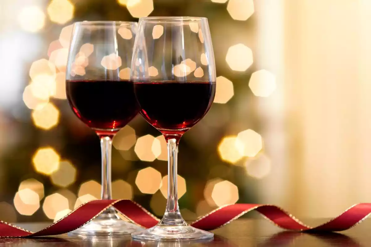 Dos copas de vino tinto con decoración navideña