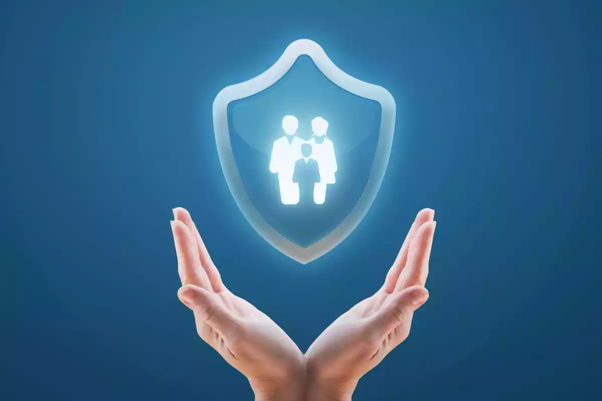 Imágen de dos manos sujetando un escudo con una familia en el interior en señal de seguridad