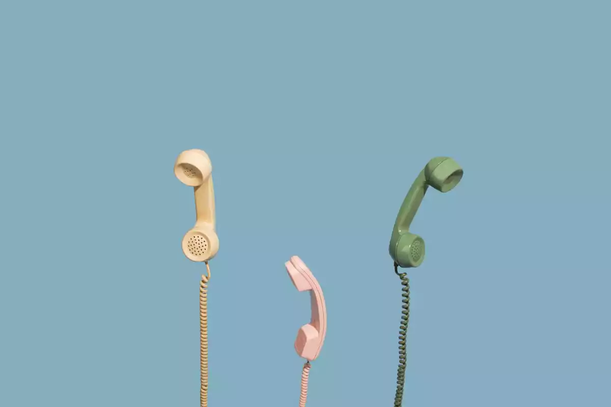 Imágen de tres teléfonos fijos colgando de sus hilos