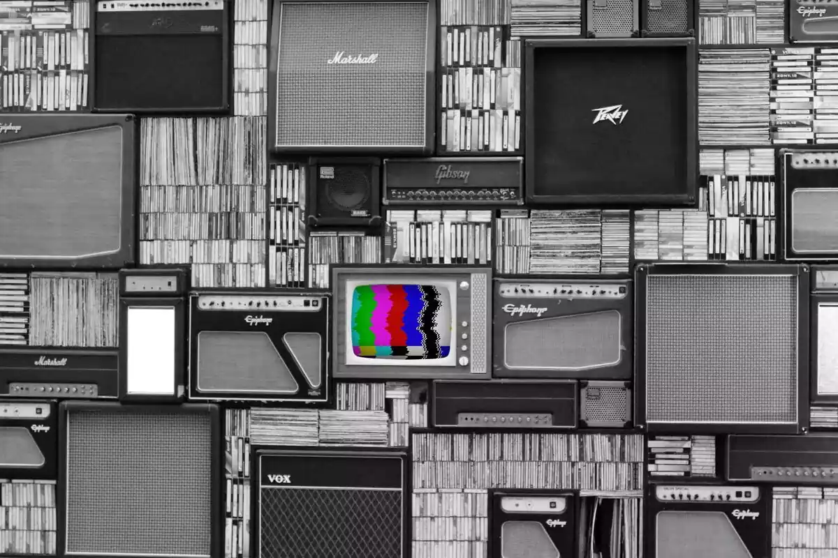 Imágen donde aparecen muchos televisores antiguos en planco y negro y en el centro uno que aparece con color en la pantalla