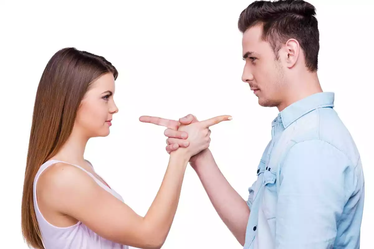 Un hombre y una mujer frente a frente señalándose con el dedo