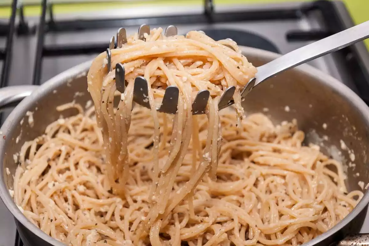 Imagen de una olla llena de espaguetis y una cuchara