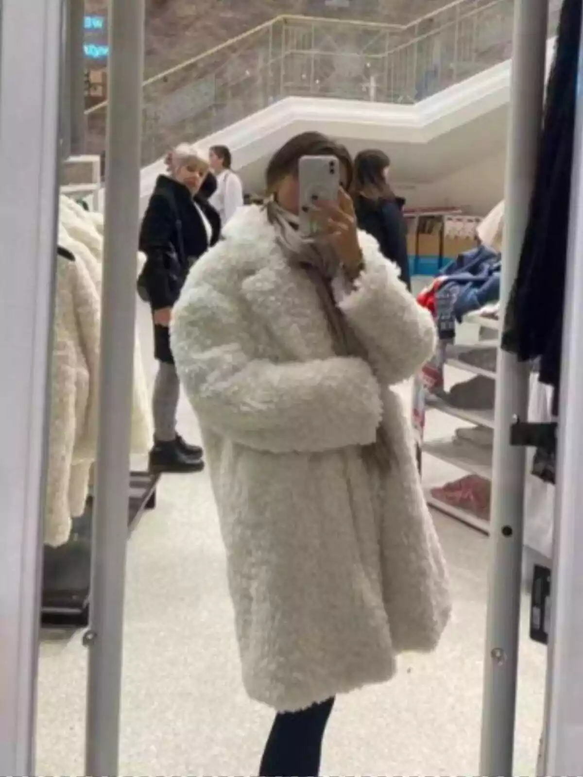 Chica con abrigo blanco de pelo sintético de la colección de Primark con Rita Ora