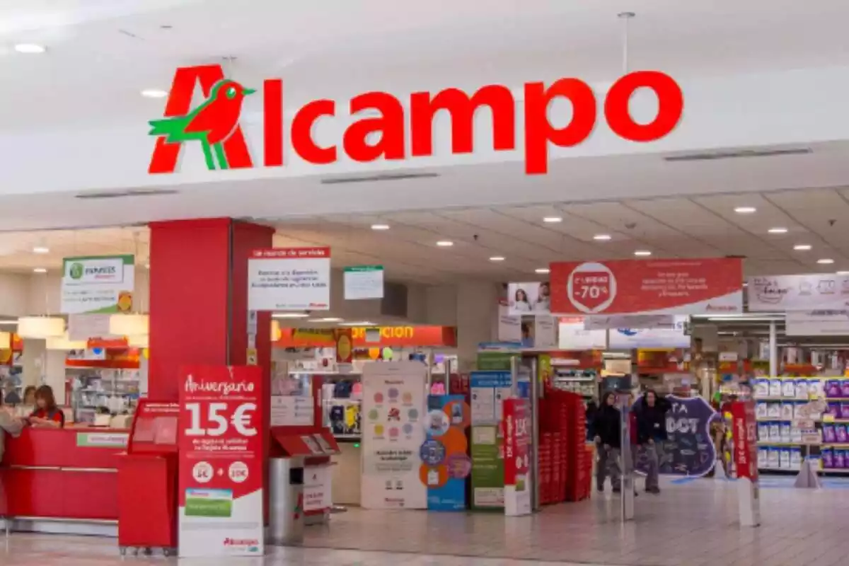Primer plano exterior de una tienda Alcampo, con el logo de la cadena en color rojo