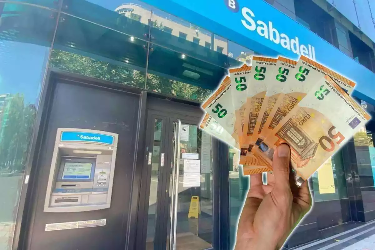 Mano sujetando billetes de 50 euros y cajero del Banco Sabadell