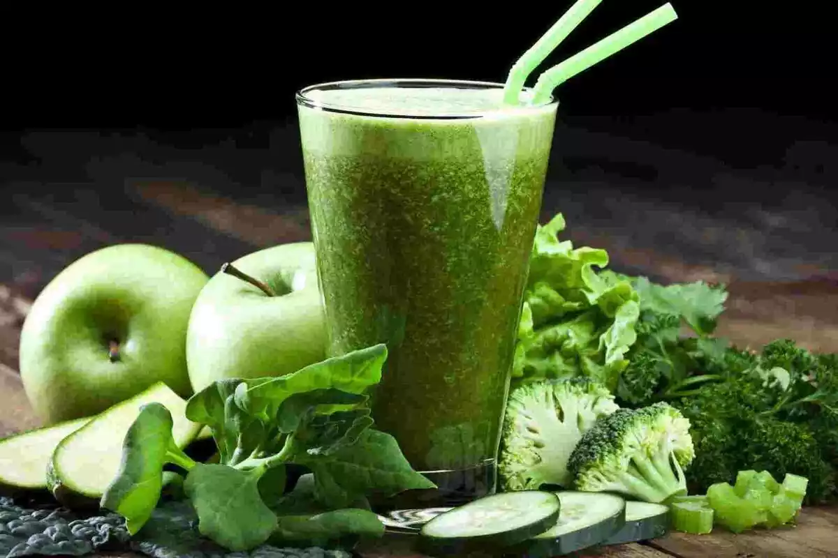 Batido verde junto con frutas y verduras de tonos verdes
