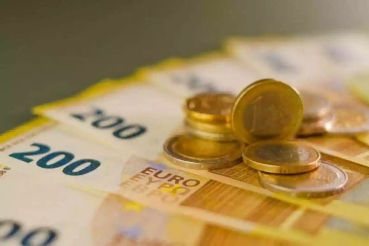 Muchos billetes de 200 euros debajo de monedas de 1 euro y 2 euros