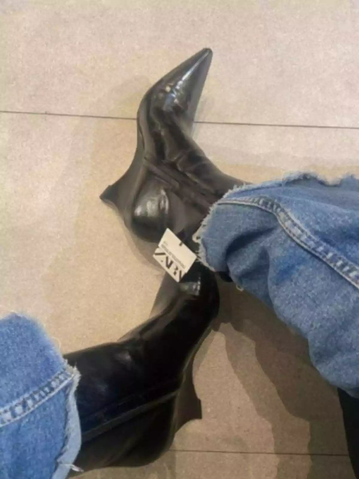 Persona con botines de tacón cuña negros de Zara