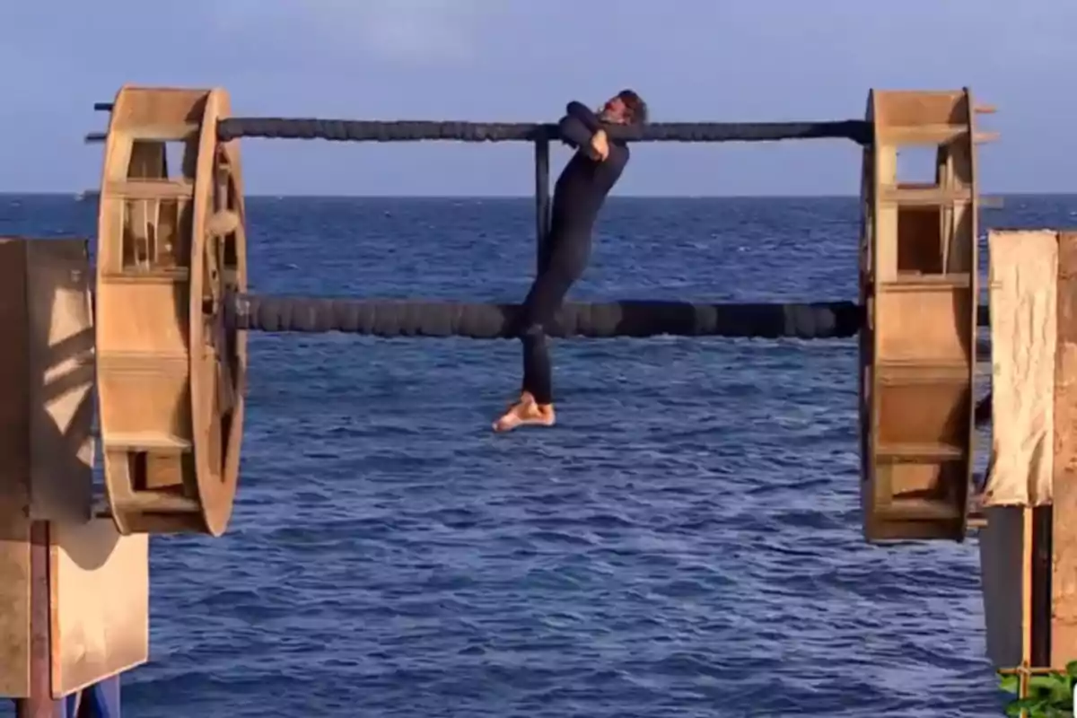 Persona colgando de una estructura giratoria sobre el mar durante una competencia de destreza física