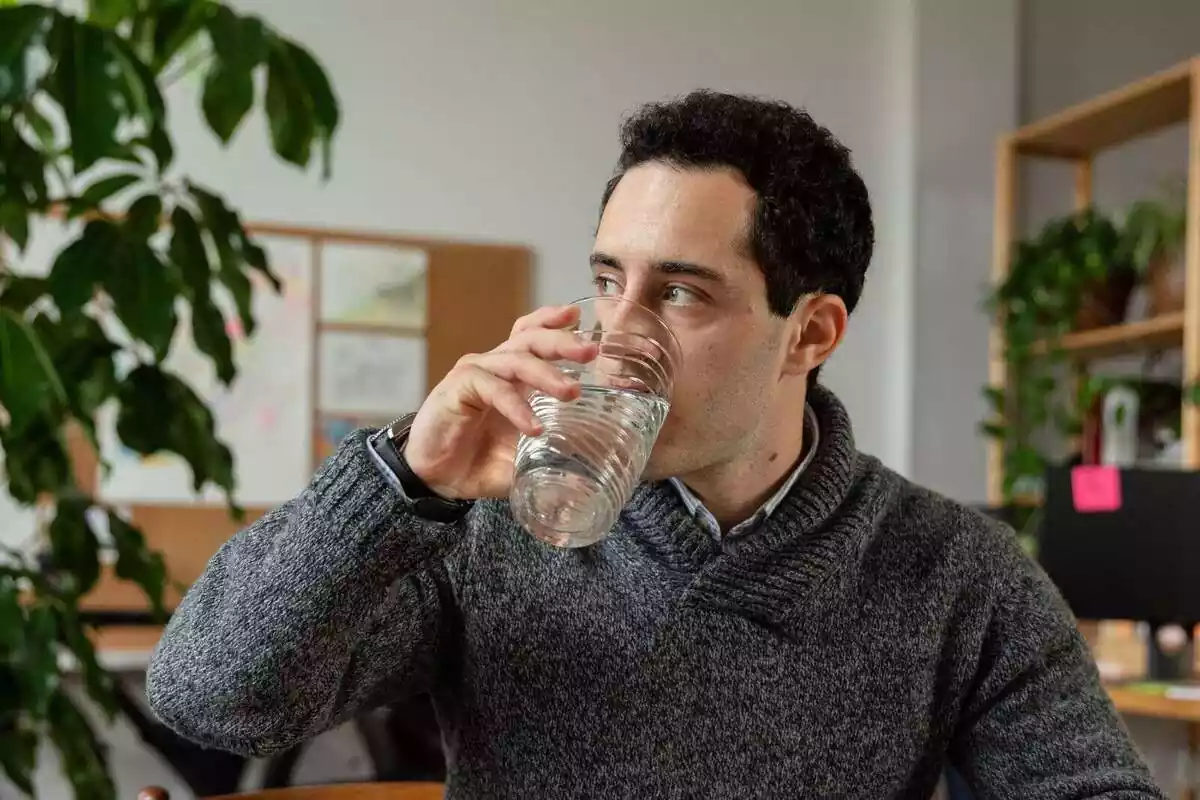 Hombre con un vaso de agua bebeiendo