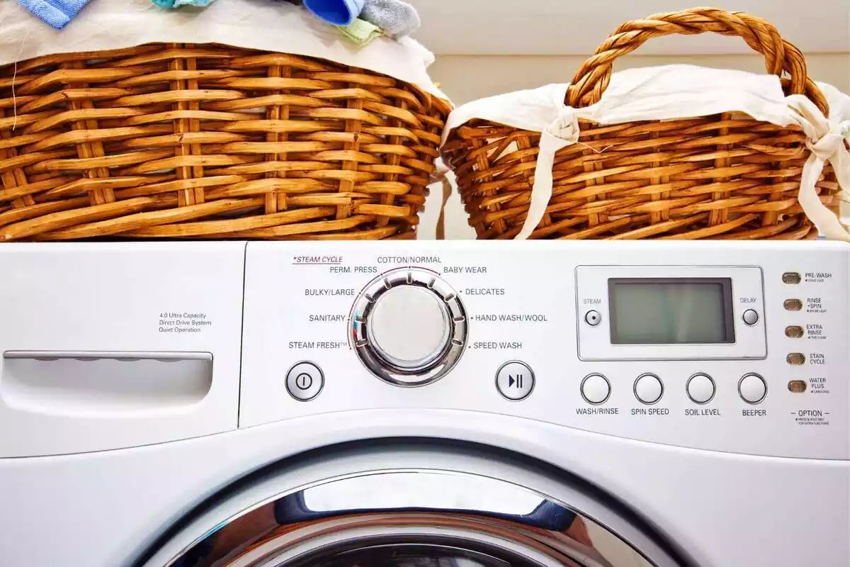 Primer plano de dos cestos pequeños de ropa encima de una lavadora