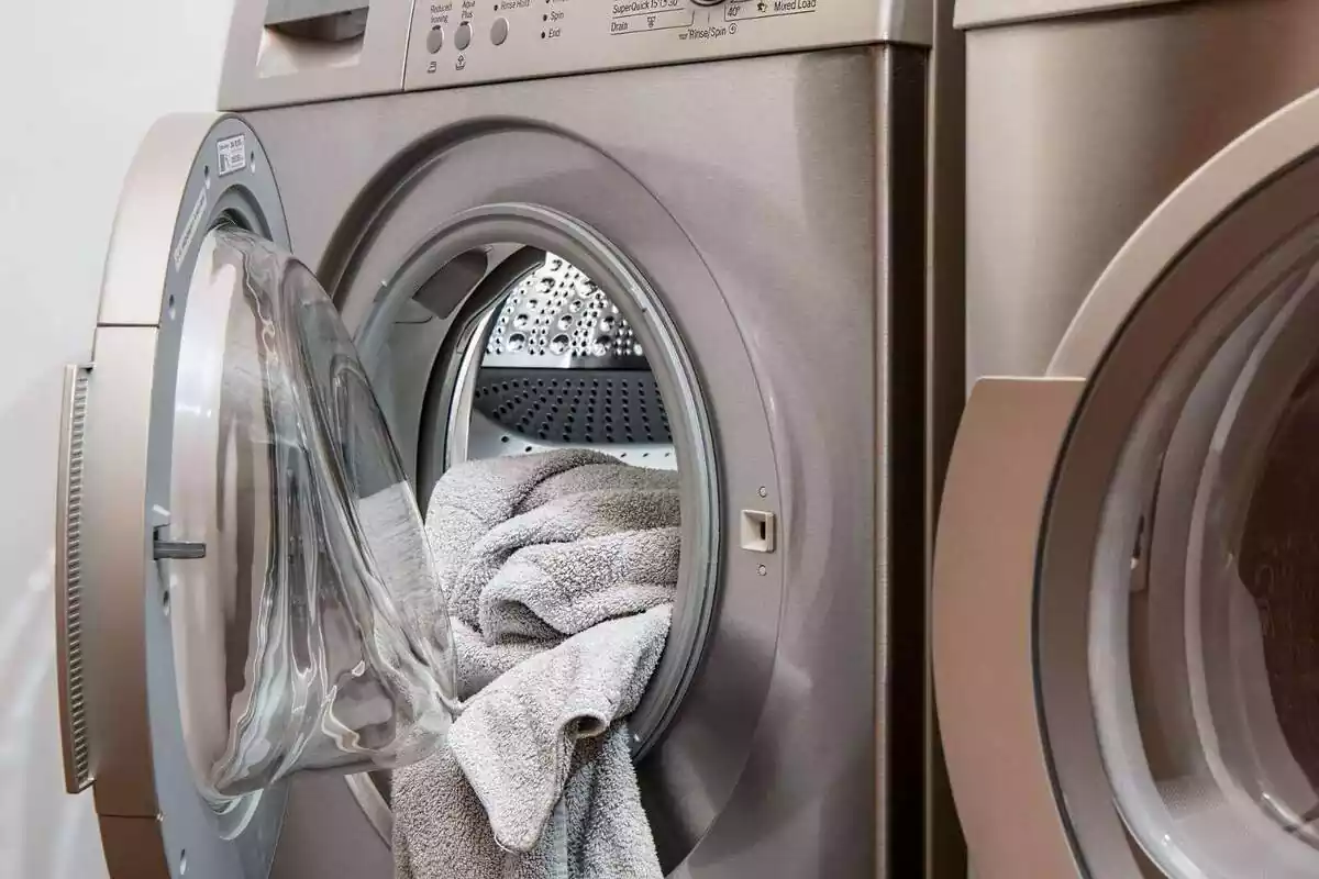 Una lavadora con la puerta abierta y una toalla dentro