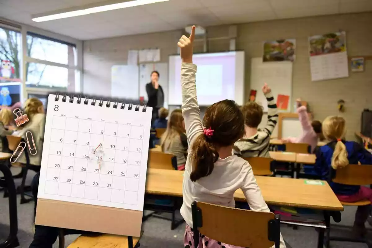 Montaje con el interior de una clase con niños levantando el brazo y un calendario