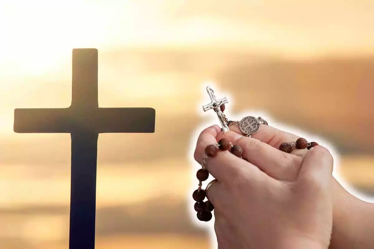Montaje de una cruz católica y unas manos con un rosario