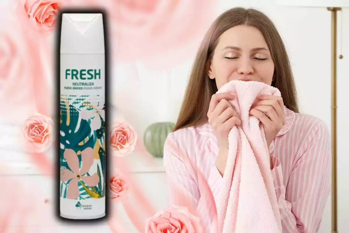 Una mujer sonriente huele una toalla rosa mientras sostiene un ambientador en aerosol con diseño floral de Mercadona y fondo decorado con rosas. Una mujer sonriente huele una toalla rosa mientras sostiene un ambientador en aerosol con diseño floral de Mercadona y fondo decorado con rosas.