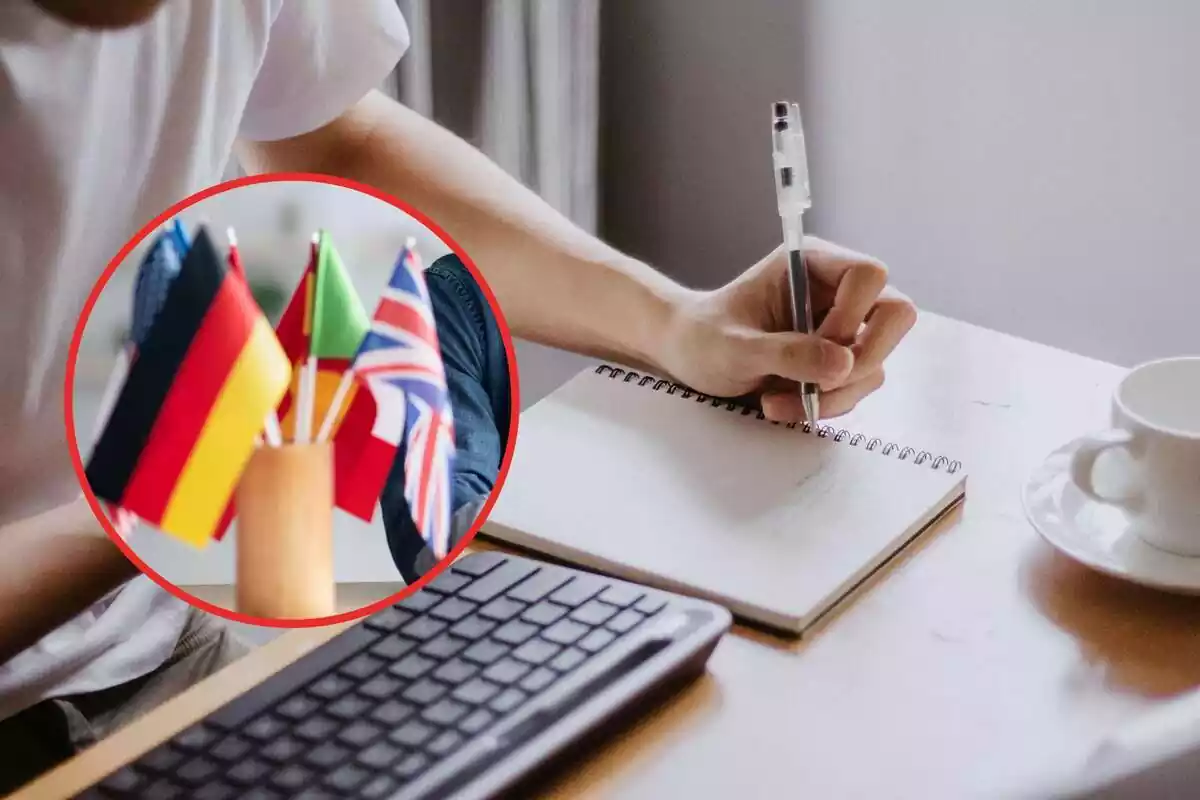 Montaje de un escritorio con una libreta y un teclado y una redonda con banderitas de diferentes países
