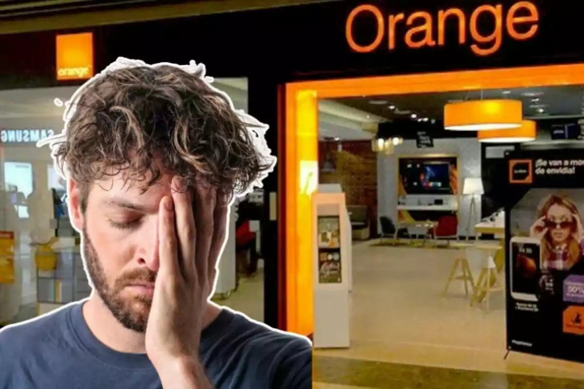 Un hombre con expresión de frustración se cubre la cara con una mano frente a una tienda de la compañía Orange.