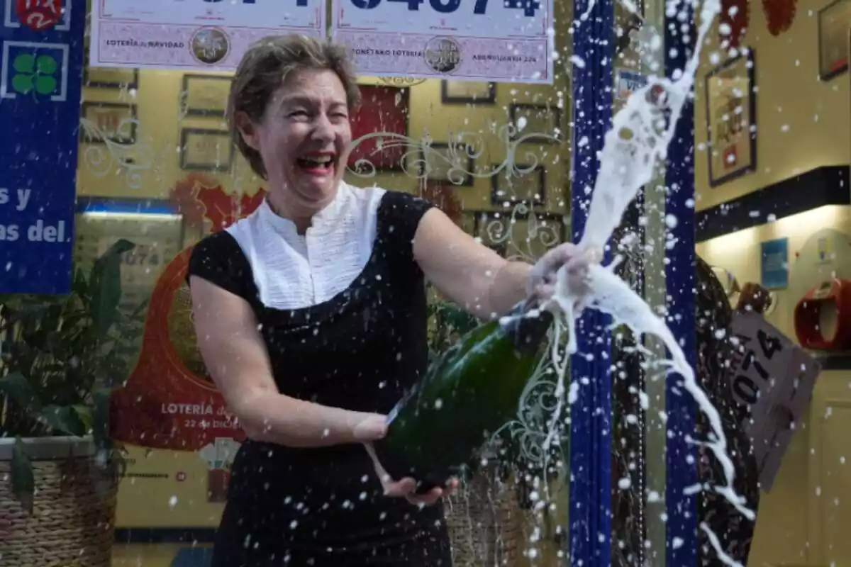Una mujer saltando de alegría celebrando que ha ganado la lotería con cava
