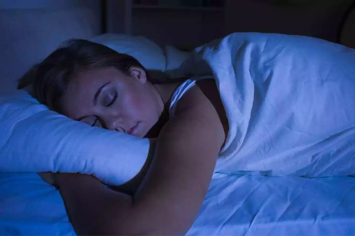 Mujer joven durmiendo profundamente sin luz artificial