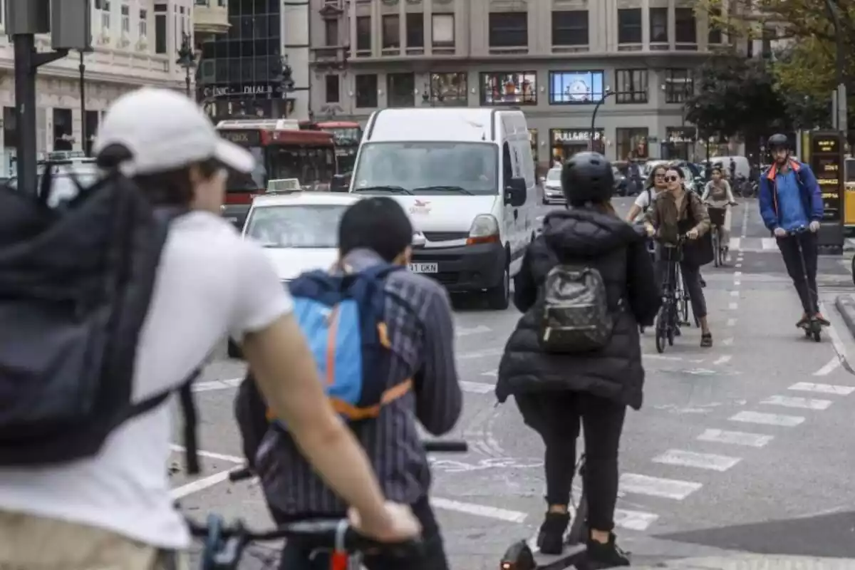 Paso de peatones con personas circulando en diferentes tipos de transporte