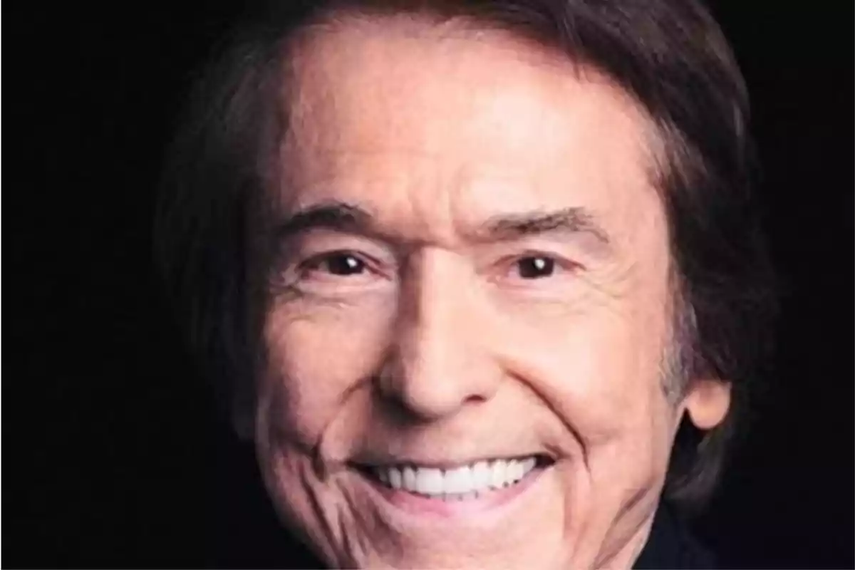 Un hombre mayor sonriendo con el cabello oscuro y fondo negro. Un hombre mayor sonriendo con el cabello oscuro y fondo negro.