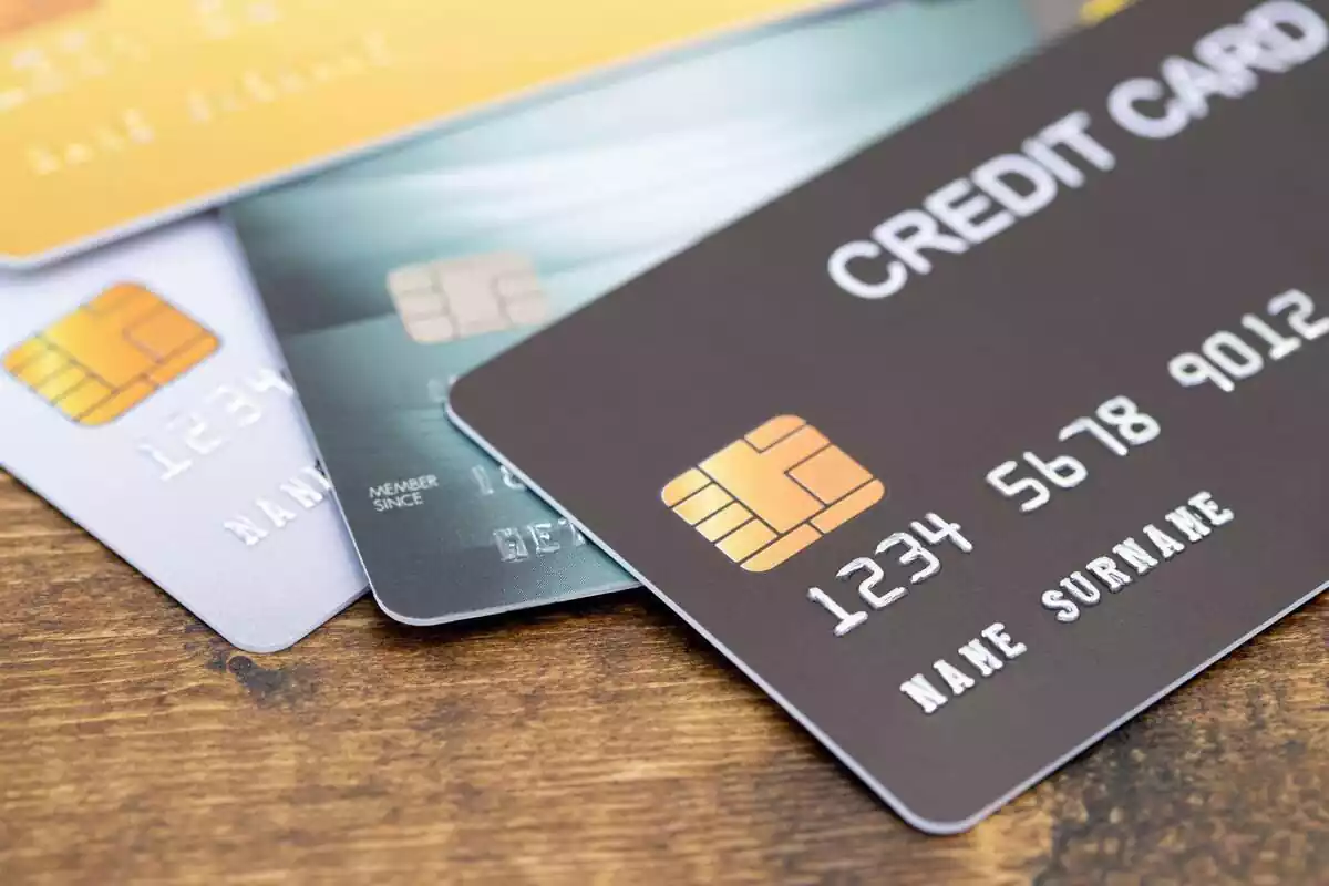 Tres tarjetas de crédito encima de una superfície de madera
