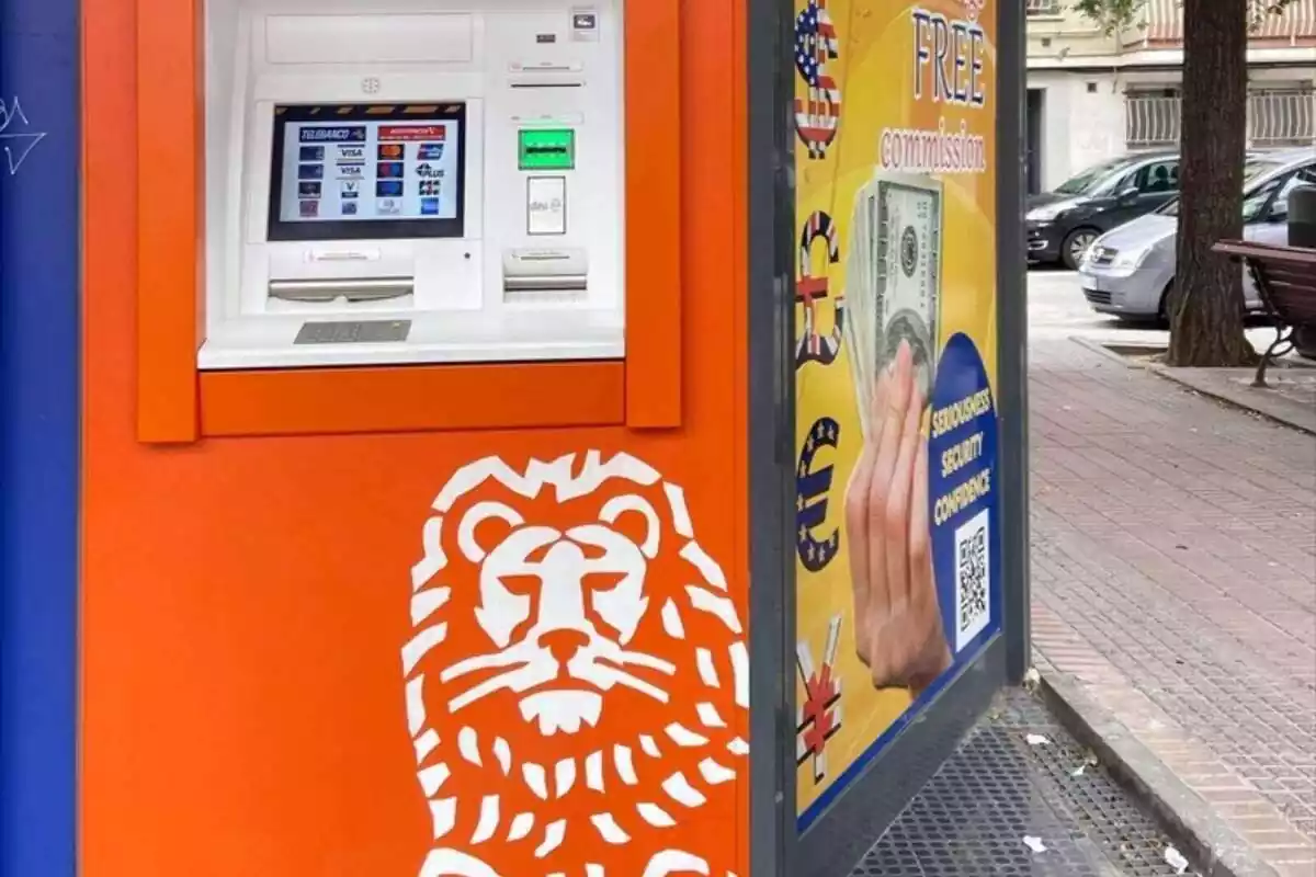 Un cajero naranja del banco ING en el exterior con el dibujo de un león en blanco
