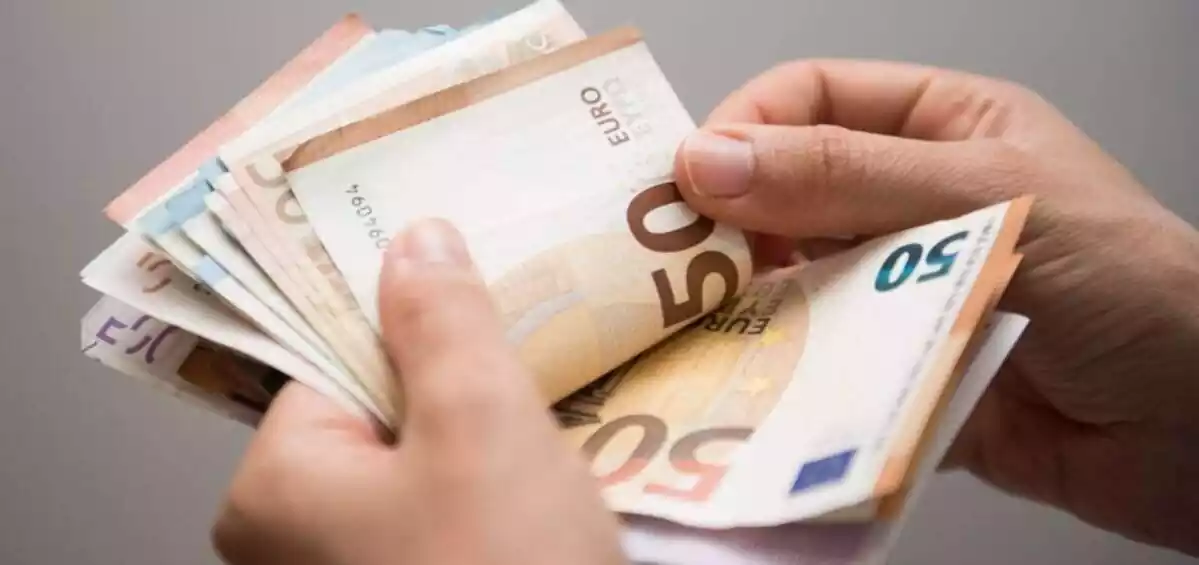 Una persona contando billetes de euros con los dedos